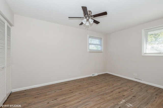 empty room featuring ceiling fan and dark hardwood / wood-style flooring