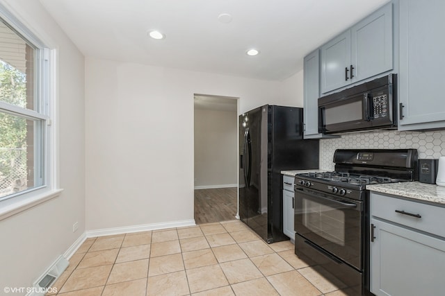 kitchen with gray cabinets, light tile patterned flooring, backsplash, and black appliances