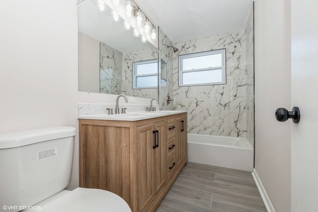 full bathroom featuring wood-type flooring, vanity, toilet, and tiled shower / bath combo