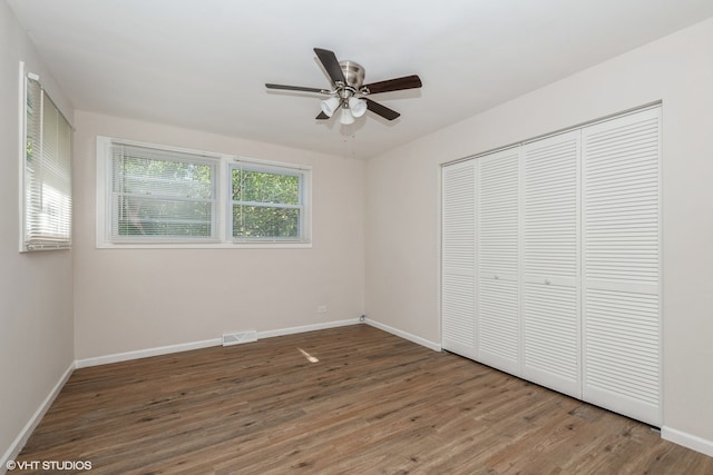 unfurnished bedroom featuring ceiling fan, a closet, and hardwood / wood-style floors