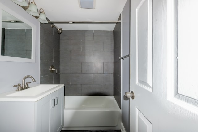 bathroom featuring tiled shower / bath and vanity