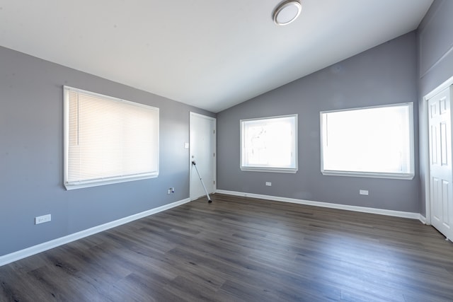 spare room featuring lofted ceiling and dark hardwood / wood-style floors