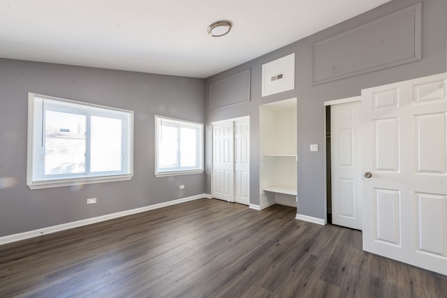 unfurnished bedroom featuring dark hardwood / wood-style floors and vaulted ceiling