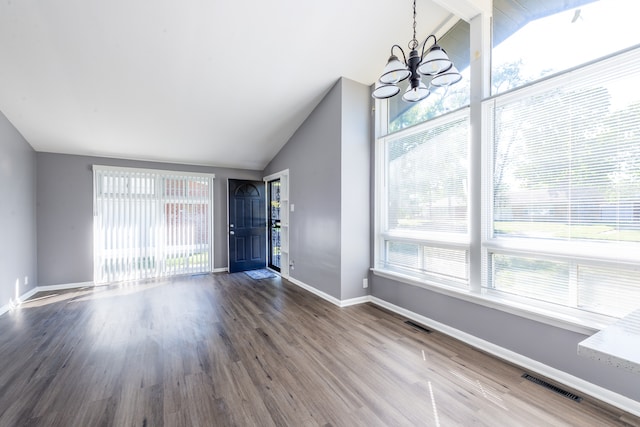 foyer featuring hardwood / wood-style flooring, a chandelier, high vaulted ceiling, and a wealth of natural light