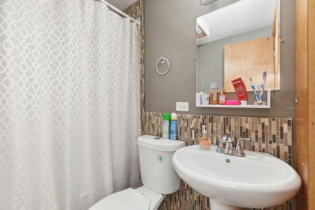 bathroom featuring sink, decorative backsplash, and toilet