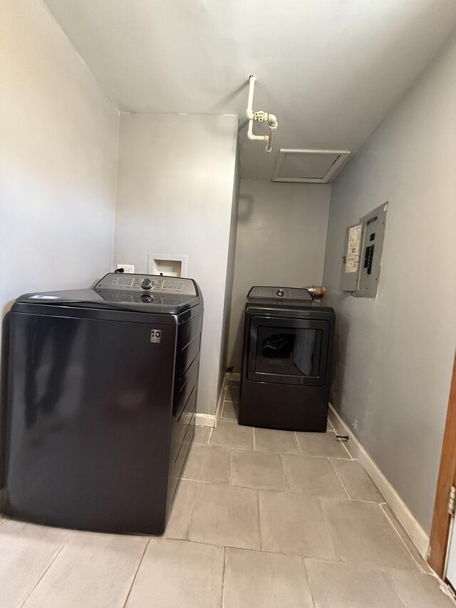 washroom featuring electric panel, light tile patterned floors, and independent washer and dryer