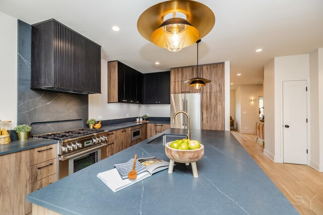2715 Reese Ave, Evanston, IL 60201 - kitchen featuring premium appliances, a sink, modern cabinets, range hood, and dark countertops
