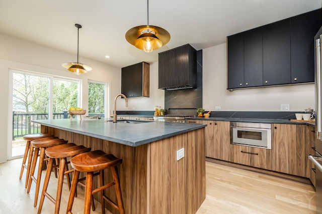 2715 Reese Ave, Evanston, IL 60201 - kitchen with a sink, light wood-type flooring, a breakfast bar area, decorative light fixtures, and stove