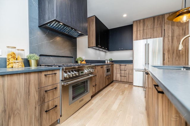 2715 Reese Ave, Evanston, IL 60201 - kitchen with high quality appliances, wall chimney range hood, light wood-type flooring, a sink, and recessed lighting