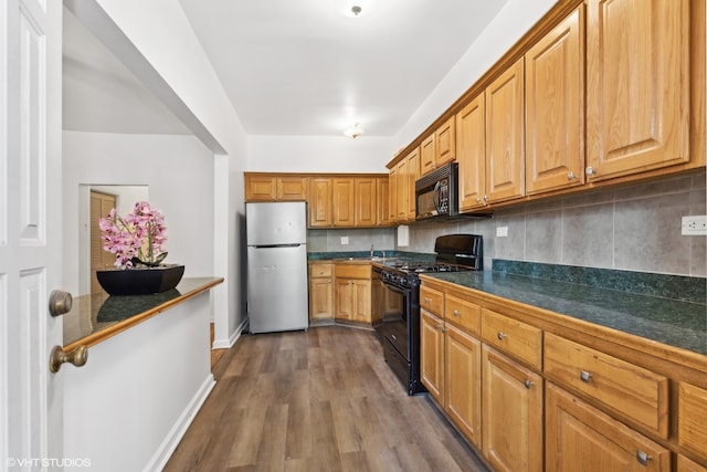 kitchen with black appliances, backsplash, and dark hardwood / wood-style flooring