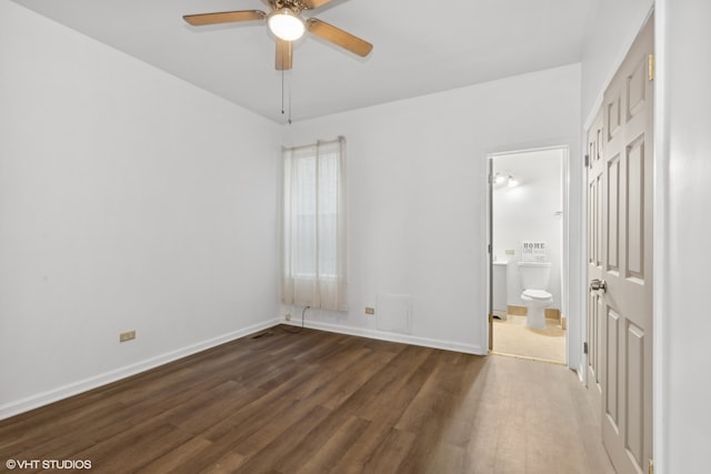 unfurnished bedroom with ceiling fan, connected bathroom, and dark hardwood / wood-style flooring