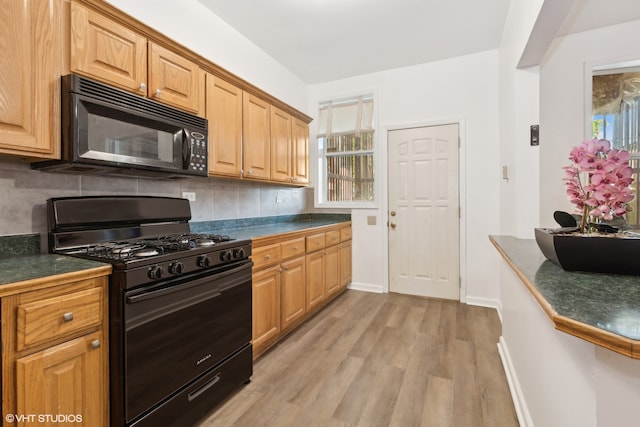 kitchen with decorative backsplash, black appliances, and light wood-type flooring