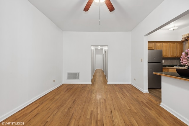 kitchen featuring light hardwood / wood-style floors, stainless steel fridge, sink, and ceiling fan