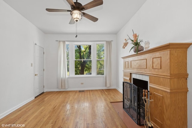 6049 S Eberhart Ave Unit 1-N, Chicago, IL 60637 - living room featuring light wood-style flooring, baseboards, a fireplace with flush hearth, and a ceiling fan