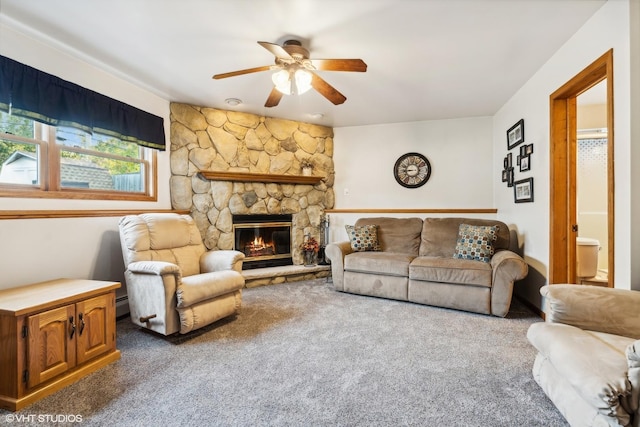 carpeted living area with a fireplace, a baseboard heating unit, and a ceiling fan