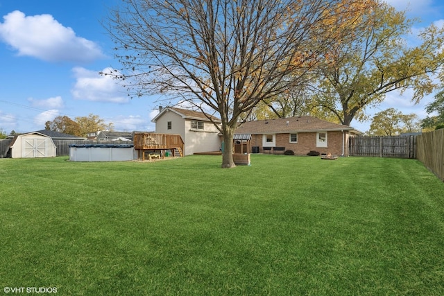 view of yard featuring a fenced backyard, an outdoor structure, a fenced in pool, and a shed