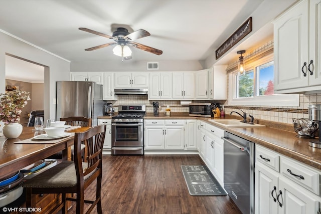 kitchen with visible vents, white cabinets, a sink, appliances with stainless steel finishes, and under cabinet range hood