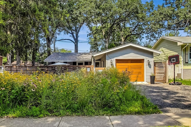 view of front of house with a garage and gravel driveway