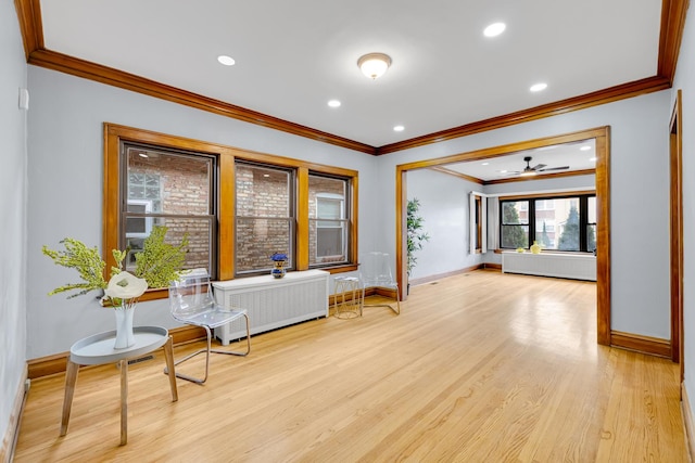 sitting room featuring ceiling fan, crown molding, radiator, and light hardwood / wood-style flooring