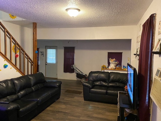 living room with a textured ceiling and dark wood-type flooring