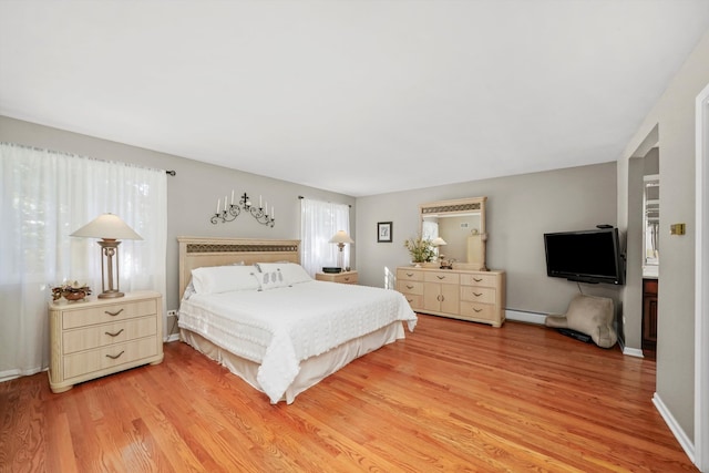 bedroom with wood-type flooring and baseboard heating