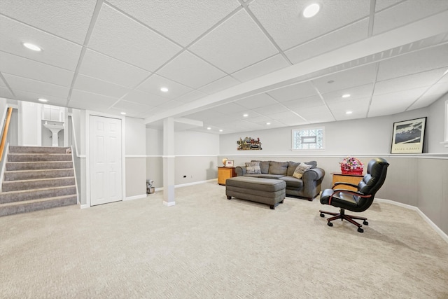 carpeted living room with a drop ceiling