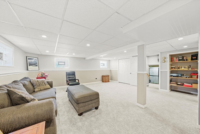 carpeted living room featuring a drop ceiling