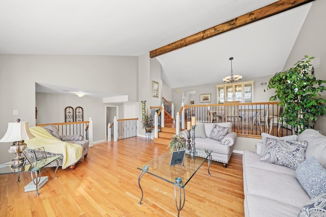 living room featuring wood-type flooring, an inviting chandelier, and vaulted ceiling with beams