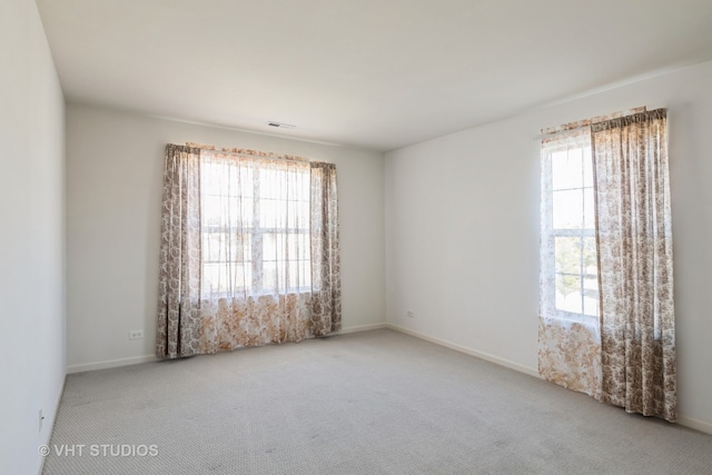 carpeted empty room featuring plenty of natural light