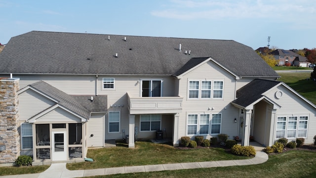 rear view of property with a sunroom and a yard