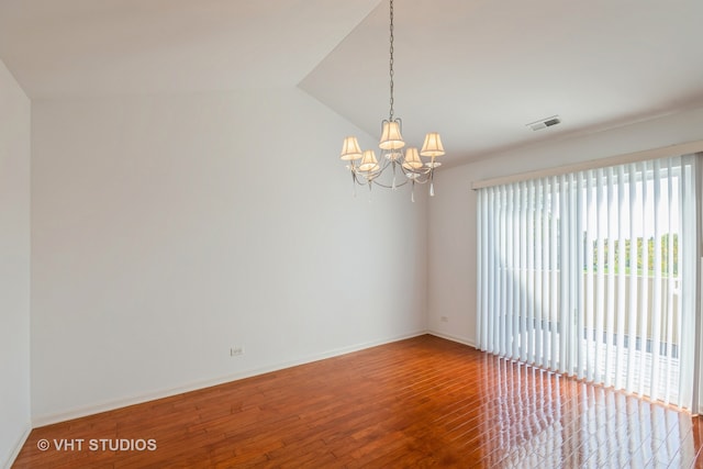 unfurnished room featuring lofted ceiling, hardwood / wood-style floors, and a chandelier