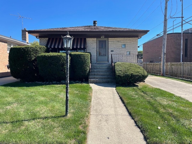 679 Manistee Ave, Calumet City, IL 60409 - view of front facade featuring fence, a front yard, and brick siding