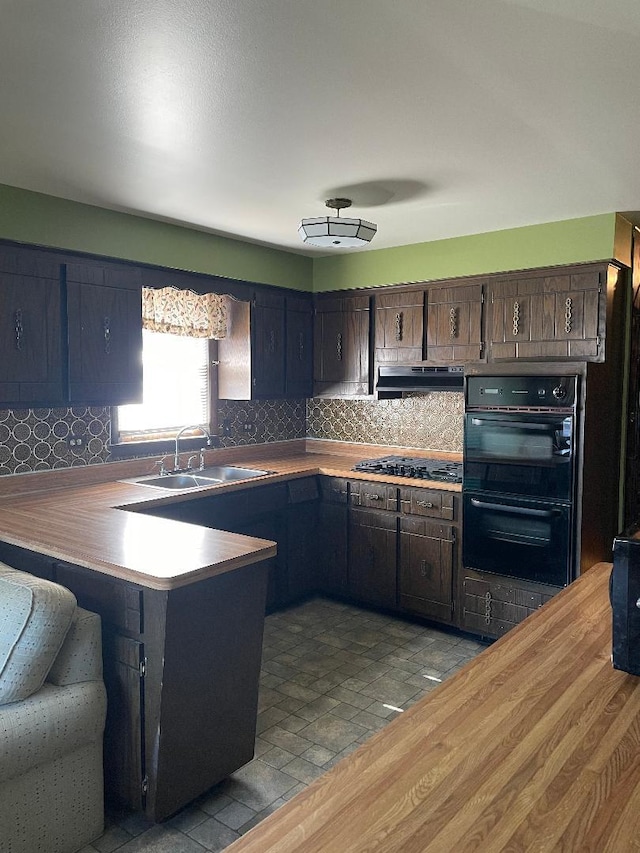 kitchen with kitchen peninsula, dark brown cabinets, light hardwood / wood-style floors, double oven, and sink