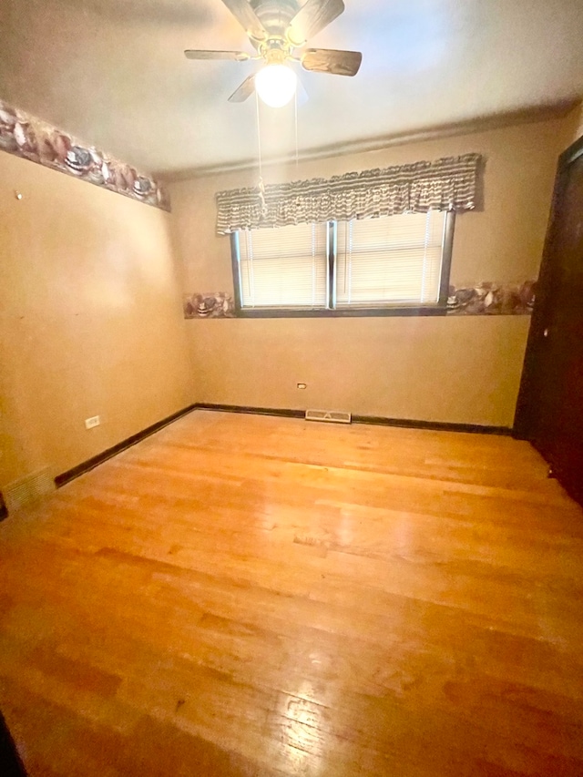 unfurnished room featuring hardwood / wood-style floors, crown molding, a healthy amount of sunlight, and ceiling fan