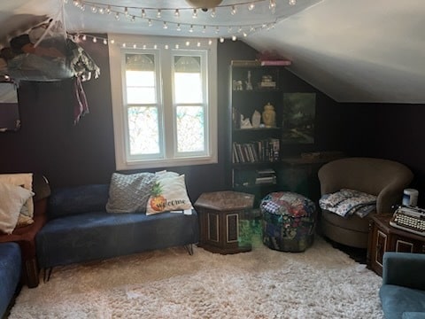 sitting room with a healthy amount of sunlight, carpet flooring, and vaulted ceiling