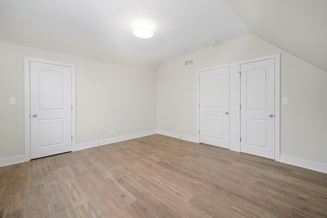 additional living space featuring light hardwood / wood-style flooring and vaulted ceiling