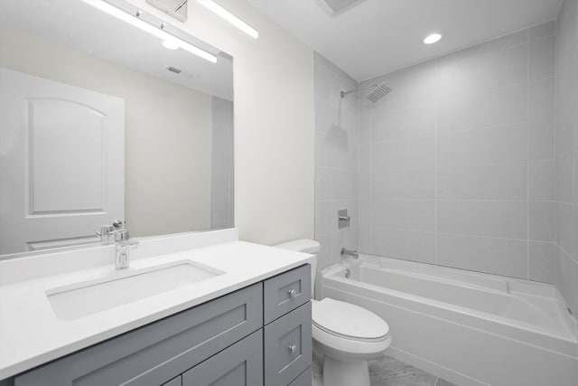 full bathroom featuring tiled shower / bath, vanity, and toilet