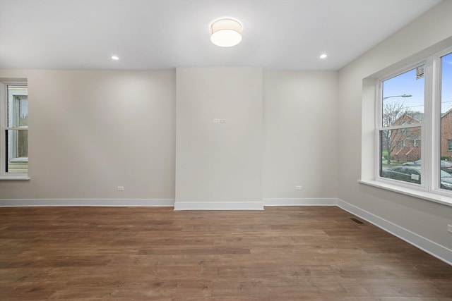 empty room featuring wood-type flooring and a healthy amount of sunlight