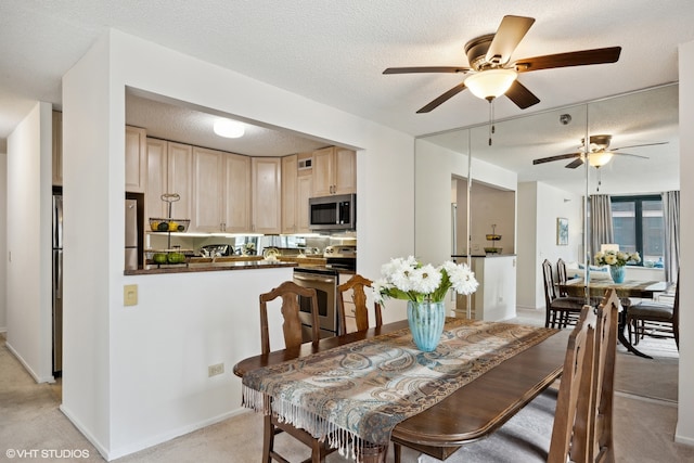 carpeted dining space featuring a textured ceiling and ceiling fan