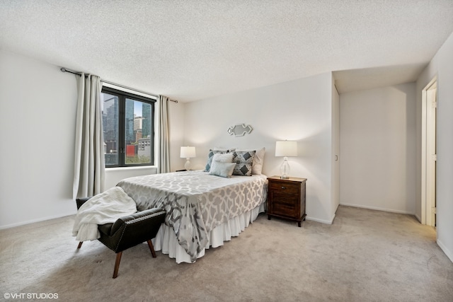 bedroom with a textured ceiling and light colored carpet