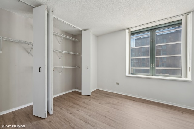 unfurnished bedroom with a textured ceiling and light hardwood / wood-style floors