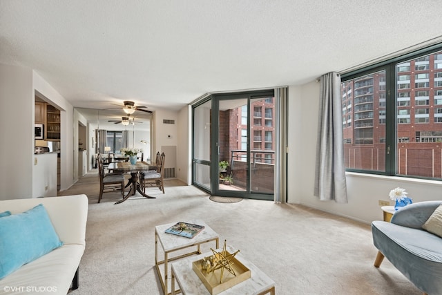 living room featuring ceiling fan, light colored carpet, and a textured ceiling