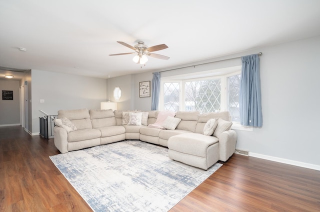 living room with ceiling fan and dark wood-type flooring