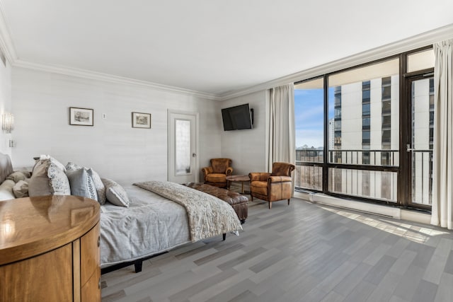 bedroom featuring a wall of windows, hardwood / wood-style floors, and crown molding