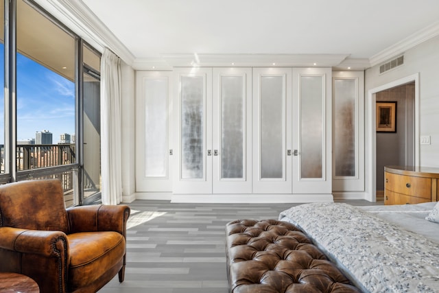 bedroom featuring dark hardwood / wood-style flooring, multiple windows, and crown molding