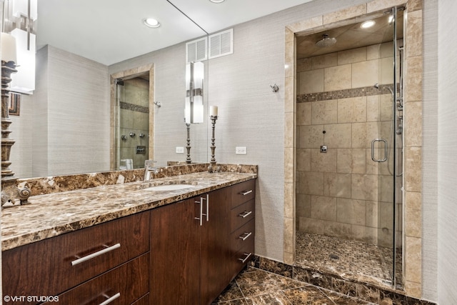 bathroom featuring vanity and a shower with shower door