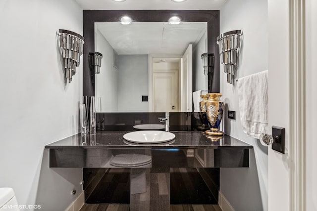 bathroom with toilet, vanity, and hardwood / wood-style floors