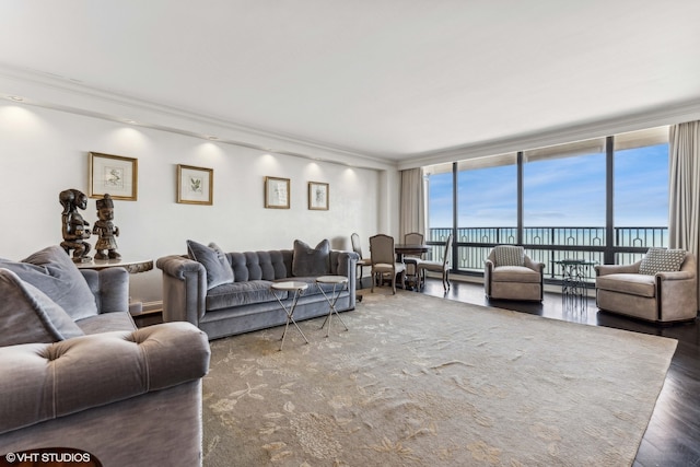 living room with dark wood-type flooring, crown molding, a water view, and floor to ceiling windows