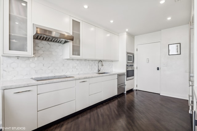 kitchen featuring stainless steel appliances, wall chimney range hood, dark hardwood / wood-style floors, sink, and white cabinets