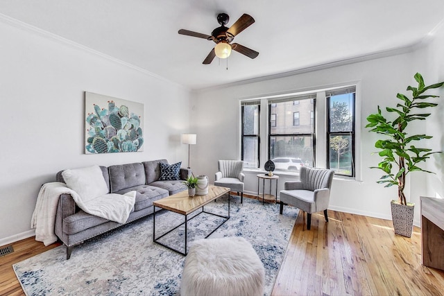 living room featuring crown molding, light wood-type flooring, and ceiling fan